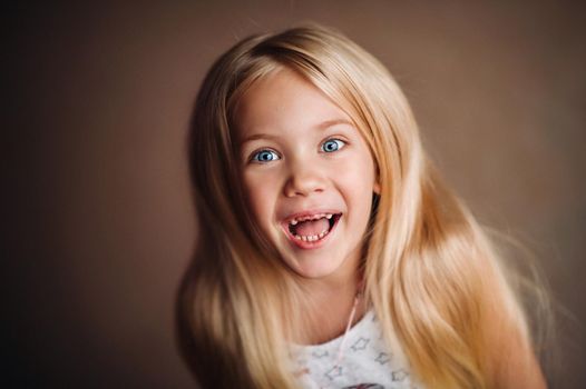 Charming child in the crib. Charming baby in yellow holds the handrails and laughs.