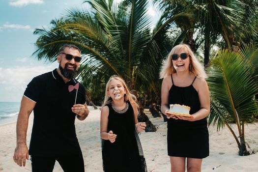 Happy beautiful family on a tropical beach celebrates the birth of their daughter.Family celebrates birthday on the island of Mauritius.