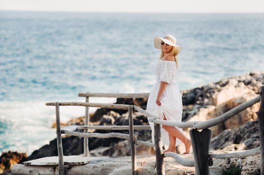 Smiling Beautiful Woman on the Beach In a Straw Hat on the island of Zakynthos.A girl in a white dress at sunset on Zakynthos island, Greece