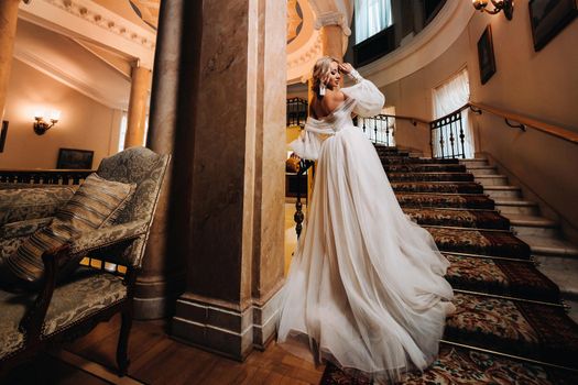 Portrait of a beautiful bride climbing a beautiful staircase.