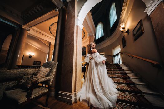 Portrait of a beautiful bride climbing a beautiful staircase.