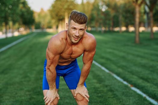 sporty man with pumped up body in park workout exercise. High quality photo