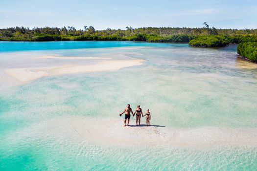 A young beautiful family with a child on the tropical island of Mauritius.The family stands on a small island in the Indian ocean.Mauritius island.