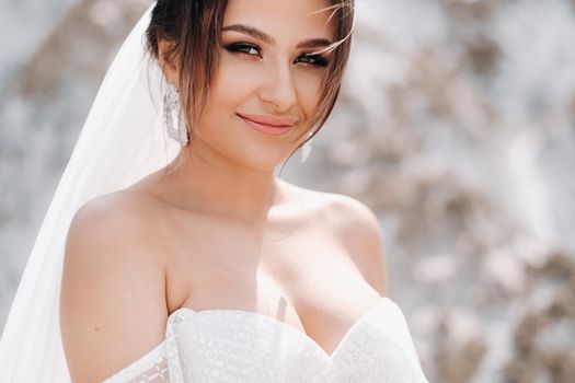 Beautiful bride in a wedding dress with a bouquet on the top of the salt mountains. A stunning young bride with curly hair . Wedding day. . Beautiful portrait of the bride without the groom.