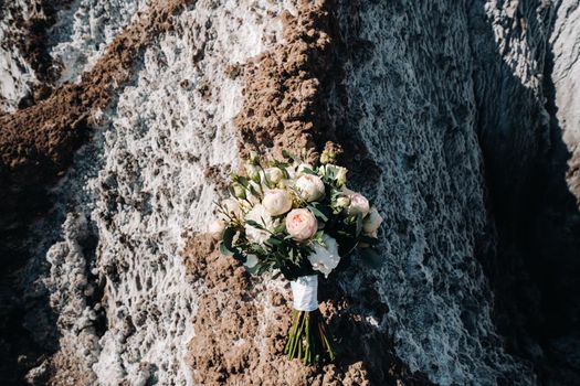 Beautiful bride is holding a wedding colorful bouquet. Beauty of colored flowers. Close-up bunch of florets. Bridal accessories. Female decoration for girl. Details for marriage and for married couple.