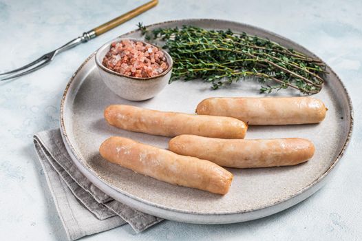 Fried chicken and turkey sausages on a plate. White background. Top view.