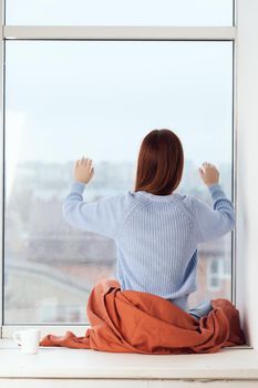 woman near the window dreamy look rest at home comfort. High quality photo