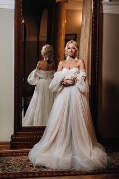 Portrait of a beautiful bride standing with her back to the mirror.
