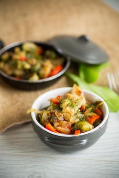 fried brussels sprouts with cauliflower and other vegetables in a bowl on a wooden table