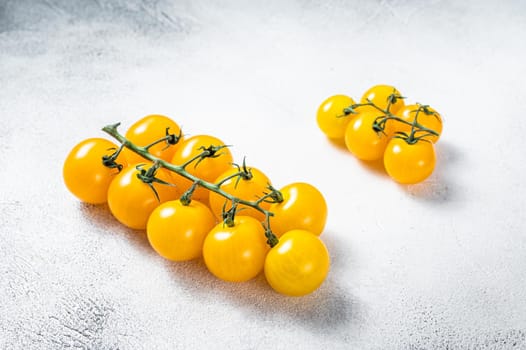 Small yellow cherry tomato on a kitchen table. White background. Top view.