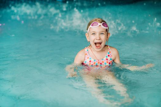 Kids play in aqua park. Children at water playground of tropical amusement park. Little girl at swimming pool. Child playing at water. Swim wear for young kid