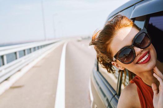 woman looking out of car window wearing sunglasses travel lifestyle. High quality photo