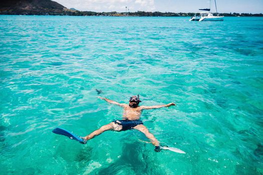 A guy in fins and a mask swims in a lagoon on the island of Mauritius.