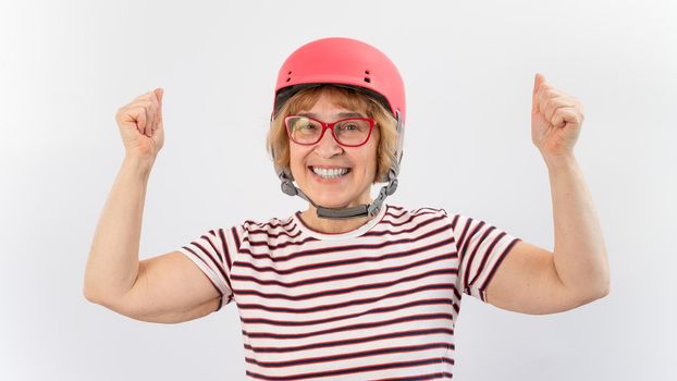 Elderly woman in ski helmet showing thumb up on white background