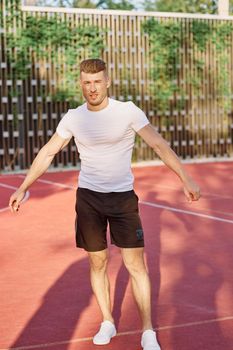 man in white t-shirt on the sports ground workout motivation. High quality photo