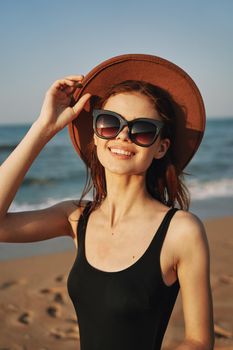 cheerful woman in sunglasses Sandy coast landscape sun. High quality photo