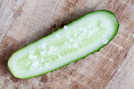 fresh green cucumber, cut into half and sprinkled with large sea salt, close-up