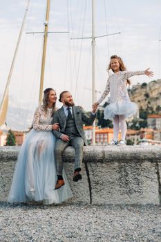 Italy, Lake Garda. Beautiful family on the shores of lake Garda in Italy at the foot of the Alps. Father, mother and daughter in Italy.