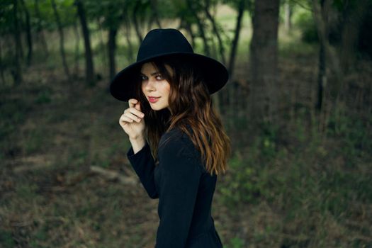 woman witch in black hat in the forest posing fantasy. High quality photo