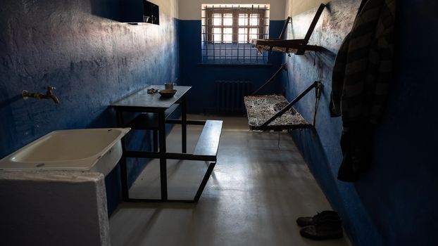 Empty double prison cell with bars on the window.