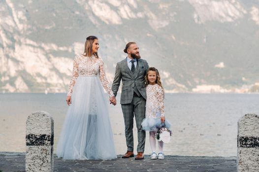 Italy, Lake Garda. Beautiful family on the shores of lake Garda in Italy at the foot of the Alps. Father, mother and daughter in Italy.