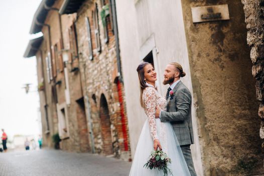 Beautiful family with walks in the old town of Sirmione in Italy.A couple strolling through old Italy.