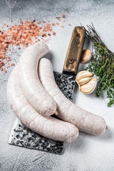 Bavarian traditional white sausages on a meat cleaver. White background. Top view.