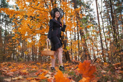 witch in the autumn forest. halloween cosplay. halloween fall holiday celebration. beautiful caucasian woman in withch costume
