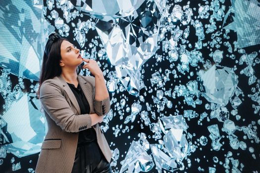 A girl in black pants and a jacket on a background of diamonds.