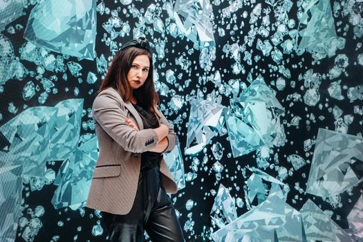 A girl in black pants and a jacket on a background of diamonds.