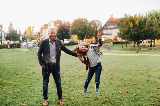 Father and daughter running on the grass in the old town of Austria.A family walks through a small town in Austria.Europe.Felden am Werten see.