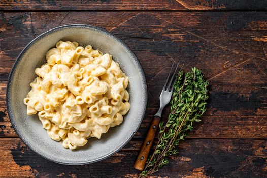 American dish Mac and cheese macaroni pasta with Cheddar. Dark wooden background. Top view. Copy space.