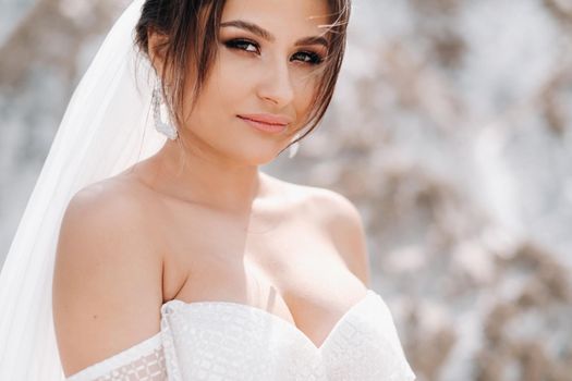 Beautiful bride in a wedding dress with a bouquet on the top of the salt mountains. A stunning young bride with curly hair . Wedding day. . Beautiful portrait of the bride without the groom.