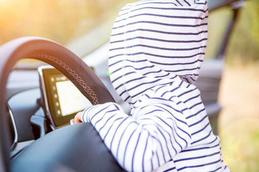 little child plays at the steering wheel of a modern car. close-up no face. interior of premium car. young driver concept