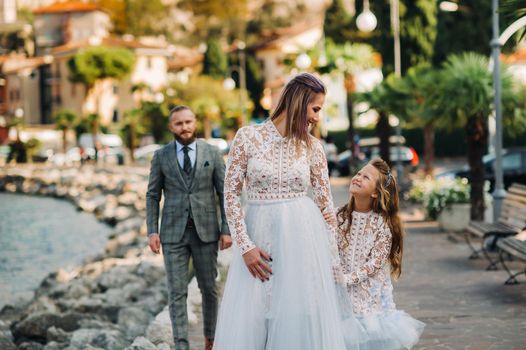 Italy, Lake Garda. Beautiful family on the shores of lake Garda in Italy at the foot of the Alps. Father, mother and daughter in Italy.