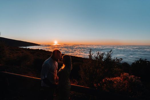 A loving man holds the girl s hand at sunset, on the background of the sea, portrait of handsome newlyweds. Photograph, concept