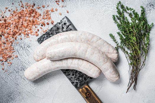 Bavarian traditional white sausages on a meat cleaver. White background. Top view.