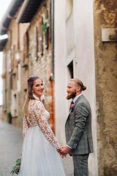 Beautiful family with walks in the old town of Sirmione in Italy.A couple strolling through old Italy.