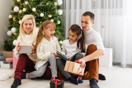 Happy family playing with Christmas gifts at home