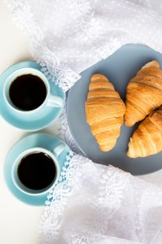 two cups of coffee with croissants on the background laces