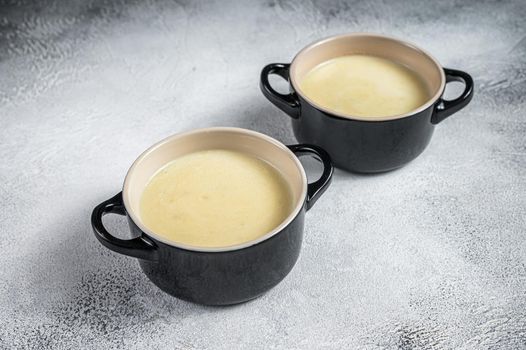 Homemade potato cream soup in bowls. White background. Top view.
