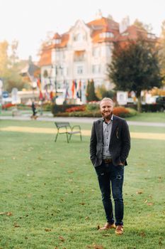 Stylish bearded man in a suit in the Park of an Austrian town