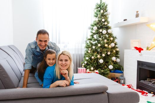 family, christmas, x-mas, winter, happiness and people concept - smiling family in santa helper hats with many gift boxes and bengal lights