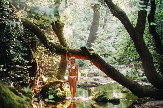 Portrait of a magnificent sexy woman in a bikini among the rainforest. Makeup, cosmetics. Beauty, fashion. Spa, healthcare. Tropical vacation