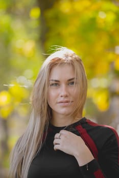 Portrait of Young attractive female posing at workout in autumn park, telephoto, close up