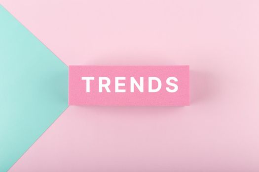 Trends written on rectangle in the middle of multicolored light blue and pink background. Minimal concept of newest, latest, hot and popular trends of any industry