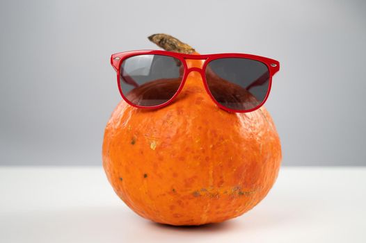 Pumpkin in sunglasses on a white background. Halloween symbol