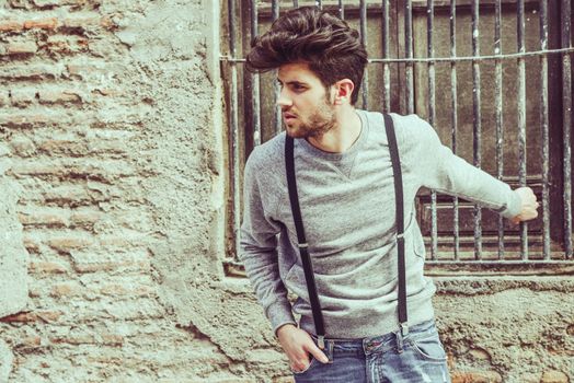 Portrait of young man wearing suspenders in urban background