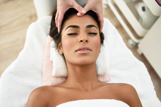 Arab woman receiving head massage in spa wellness center. Beauty and Aesthetic concepts.