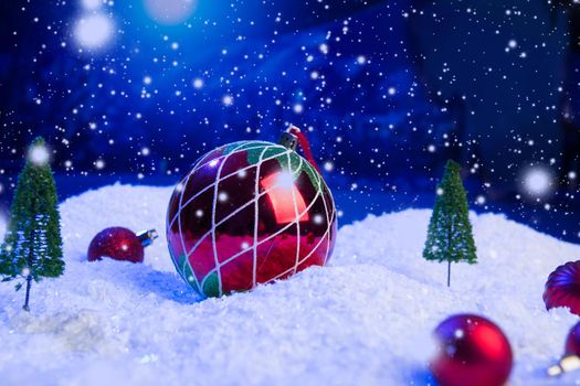 Christmas background with Christmas balls on snow over fir-tree, night sky and moon. Shallow depth of field. Christmas background. Fairy tale. Macro. Artificial magic dreamy world. .